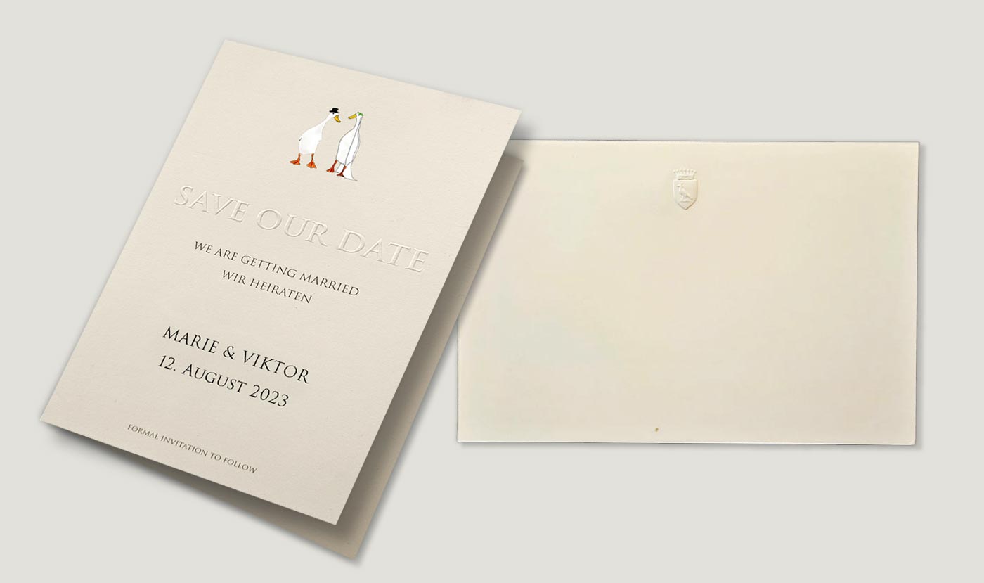 Zwei Karten mit eleganter Blindprägung, die feine Muster und Schrift erhaben darstellen.